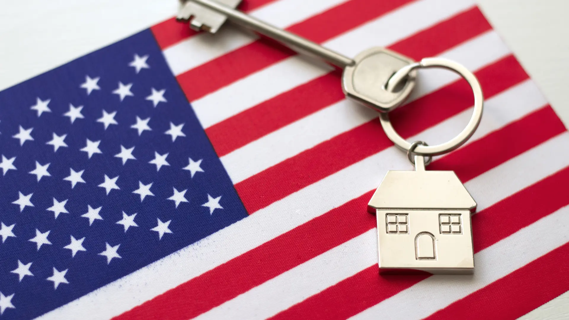 n modelo de casa sobre una bandera estadounidense representa el sueño de muchos colombianos de establecerse en Estados Unidos con el apoyo legal adecuado.