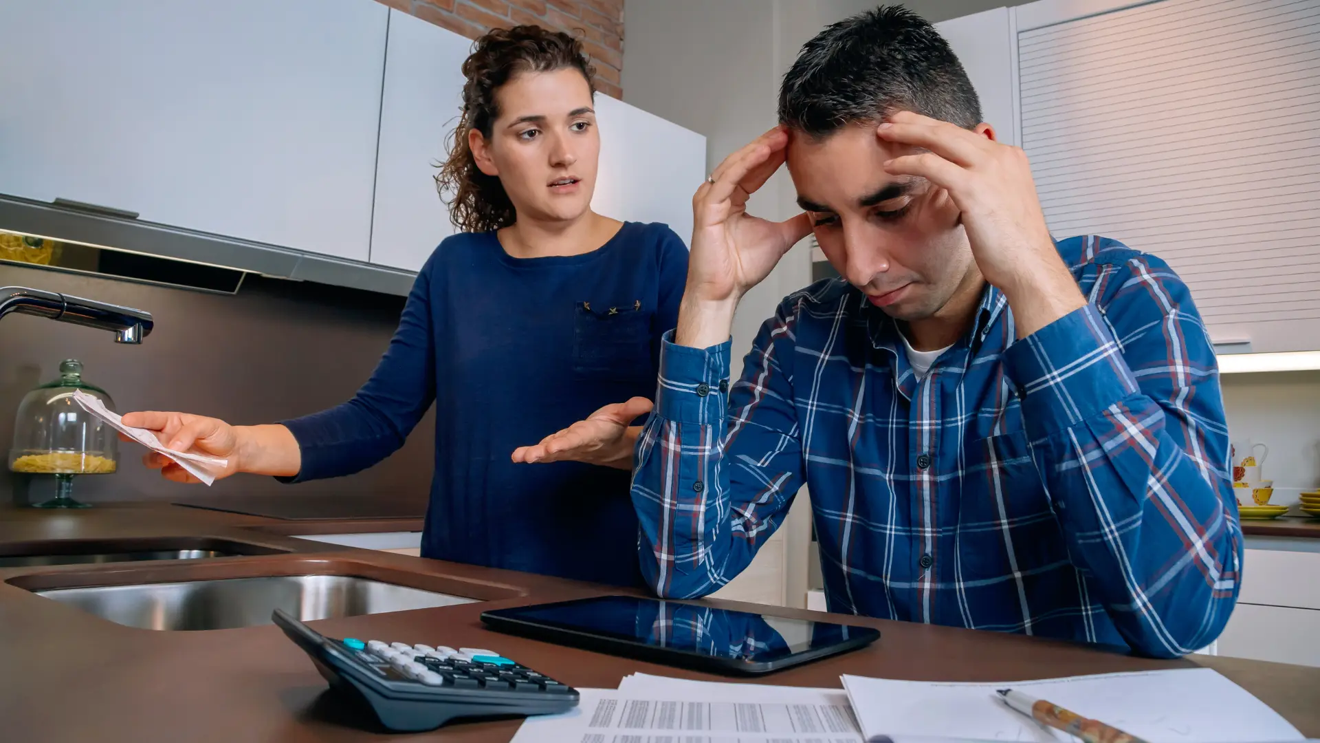 Una pareja revisa documentos financieros en relación al embargo de salario en Colombia, un proceso legal que requiere una orden judicial.